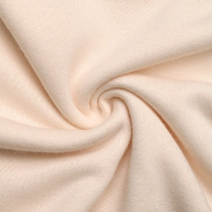 Close-up of soft knit fabric texture in beige showing detailed stitching and soft drape
