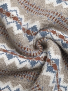 Detailed close-up of ethnic jacquard knit fabric with intricate Fair Isle geometric patterns
