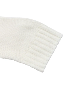 Detail of ribbed cuffs on a white knitted sweater showing fine knitting craftsmanship