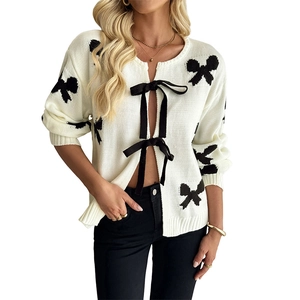 Cremefarbene Strickjacke mit schwarzen Schleifenmustern und elegantem Schleifenverschluss