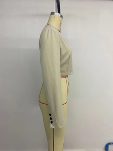 Detail view of khaki blazer sleeve showing structured shoulder pad and triple button cuff