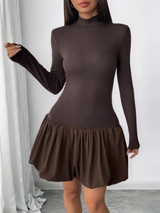 Detail of the textured ribbed fabric and flared bubble hem on a brown turtleneck dress