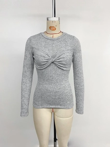 Detail view of grey long sleeve slim top featuring a central twist knot design and round neck