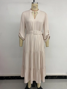 Detail of elegant beige tiered maxi dress with V-neck and a matching buckled waist belt