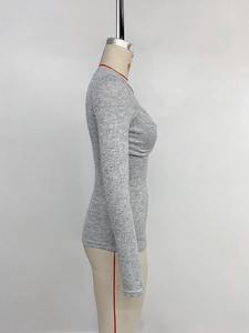 Close-up of gray slim fit knit top showing fine texture and long sleeve side detail