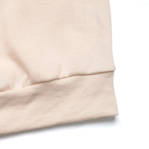 Detailed close-up of premium ribbed knit cuffs on a beige oversized sweatshirt