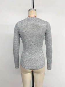 Close-up of gray long-sleeve knit top with textured fabric and slim fit design