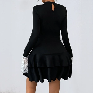 Robe noire élégante à manches longues avec poignets en dentelle et ourlet à volants