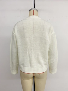Close-up of the fine knit texture and ribbed hem on the back of a white round neck sweater