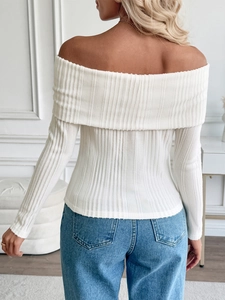 Detail of white off-shoulder knit top featuring vertical ribbed texture and long sleeves