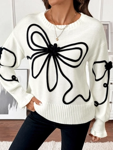Vue détaillée du pull en tricot blanc avec de grands motifs de nœuds en corde noire 3D