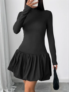 Detail of high neck knitted bodice and flared bubble skirt of black mini dress