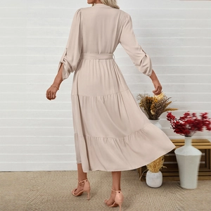 Elegant apricot tiered long sleeve dress with belt and tiered skirt shown from behind