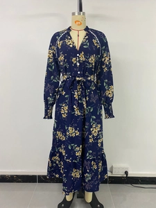Detailed close-up of navy floral dress featuring V-neck buttons and waist drawstring ties