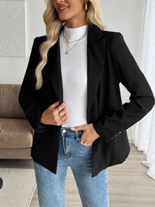 Detail of a women's black blazer with notched lapels and buttoned cuffs in a home setting