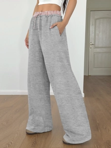 Dettaglio dei pantaloni sportivi grigi con coulisse in vita e tasche laterali capienti