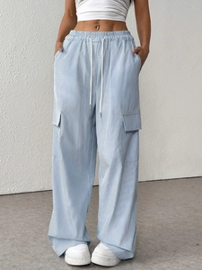 Détail du pantalon cargo à rayures bleues et blanches avec grandes poches à rabat