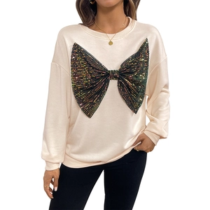 Women's beige crewneck sweatshirt featuring a large black sequin bow with colorful reflections
