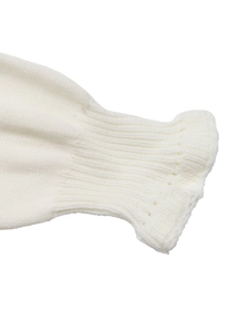Vue macro détaillée du poignet en maille côtelée sur ce pull de couleur crème
