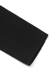 Detailed macro view showing the high-quality twill texture of the black blazer sleeve
