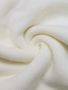 Vue macro du pull en maille crème montrant la texture douce et les détails du mélange de laine