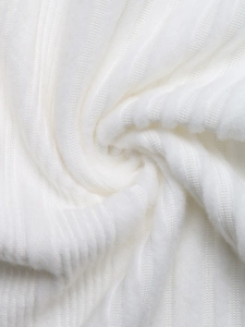 Detailed close-up of soft white ribbed knit fabric texture on a long sleeve top