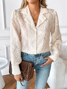 Close-up of white long sleeve shirt with unique textured feather fringe and buttoned collar