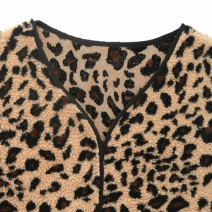 Detail shot of leopard print faux shearling vest featuring V-neck and black contrast piping