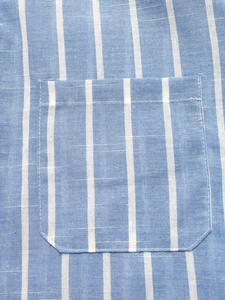 Close-up of blue and white striped shirt fabric with visible stitching on the patch pocket