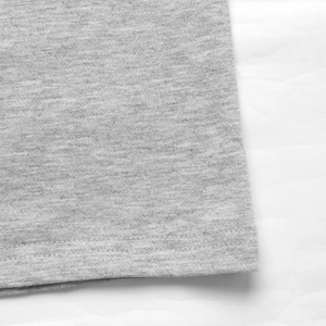 Dettaglio macro di pantaloni sportivi grigi con trama del tessuto e doppia cucitura a vista
