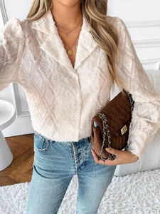 Detail of beige long sleeve shirt featuring intricate fringe texture and notch lapel
