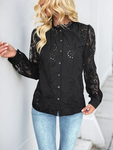 Detail of elegant black lace shirt with intricate hollow-out floral patterns and stand collar