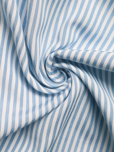 Gros plan sur la texture du tissu rayé bleu et blanc avec armure et plis doux