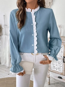 Gros plan du chemisier bleu-gris à manches longues avec détails de dentelle blanche raffinée