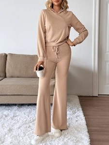 Close-up of ribbed texture on a beige knitted hoodie and high-waist flared pants set