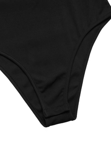 Detail view of the ribbed fabric texture and snap-button crotch closure on bodysuit