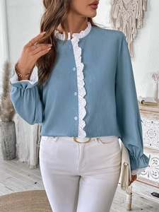 Détail de chemise bleu clair avec dentelle blanche et poignets à volants élastiques