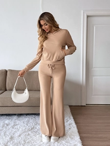 Detail of knitted hoodie and flare pants set in apricot with soft fabric texture