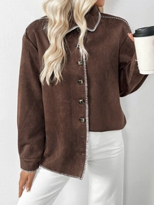 Detailaufnahme der braunen Wildlederjacke mit weißen Kontrastnähten und Knöpfen