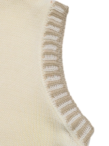 Détail des bords en tricot côtelé et coutures contrastées sur le gilet sans manches blanc