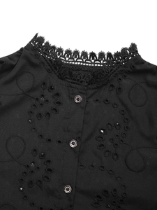 Detail of scalloped lace trim and eyelet embroidery on a black long-sleeve blouse