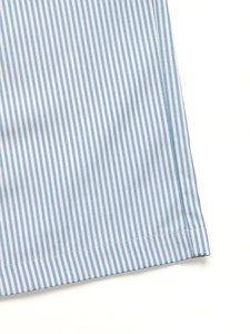 Gros plan sur la texture du tissu rayé bleu et la finition de l'ourlet à double couture