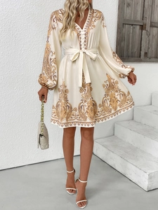 Détail d'une robe élégante à col en V, imprimé paisley, manches lanternes et ceinture nouée