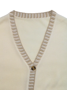 Détail du gilet en tricot à col en V avec bord rayé et bouton en écaille