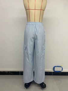 Détail du pantalon cargo à rayures verticales bleues et blanches avec grande poche à rabat