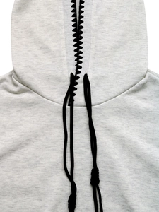 Detail of grey hoodie showing black zigzag stitching and thick corded drawstring