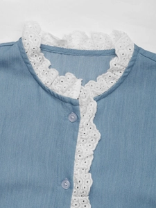 Détail de chemisier bleu clair avec dentelle blanche et boutons assortis au col
