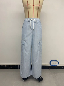 Détail du pantalon cargo rayé à taille haute avec cordon et grandes poches à rabat
