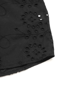 Detailed view of the intricate black lace floral embroidery and hollow out eyelet patterns