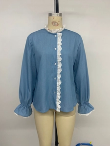 Détail de chemise bleu clair avec bordure en dentelle blanche et poignets volantés